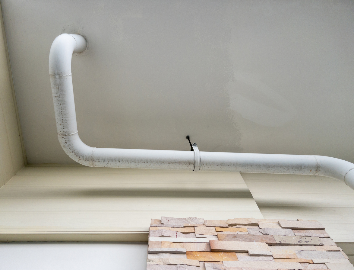 AC condensate drain line hanging on the ceiling of an office building.